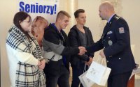 Zastępca Komendanta Powiatowego Policji w Bruntalu wręcza drobne upominki uczniom klasy mundurowej.