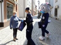 Sierż. Prudek oraz policjantka rozdaje maseczki mieszkańcom Głogówka.