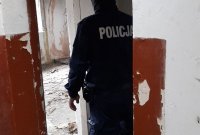 Na zdjęciu widoczny policjant kontrolujący opuszczony budynek.