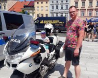 mały chłopiec siedzi na policyjnym motocyklu pod opieką rodzica